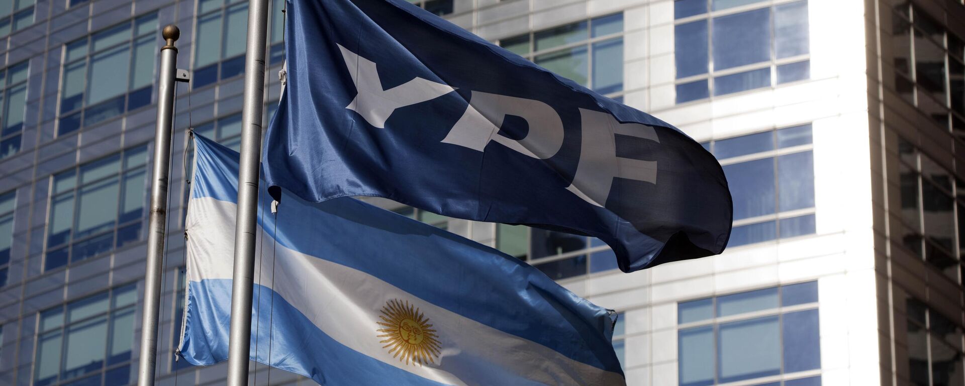 Uma bandeira nacional argentina e um banner representando a empresa petrolífera YPF tremulam do lado de fora da sede da YPF em Buenos Aires, Argentina - Sputnik Brasil, 1920, 09.09.2023