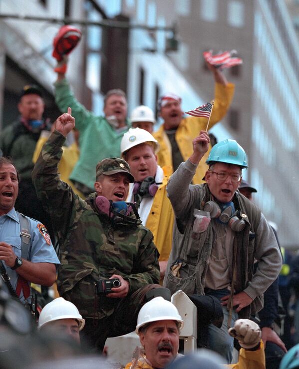 Trabalhador olha para um guindaste que move destroços para um caminhão nos restos do complexo do World Trade Center em Nova York, 5 de outubro de 2001. - Sputnik Brasil