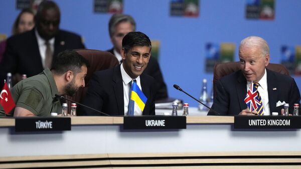 O presidente dos Estados Unidos, Joe Biden, à direita, fala com o primeiro-ministro britânico Rishi Sunak, ao centro, e com o presidente da Ucrânia, Vladimir Zelensky, durante uma reunião do Conselho OTAN-Ucrânia durante uma cimeira da OTAN em Vilnius, Lituânia, 12 de julho de 2023 - Sputnik Brasil