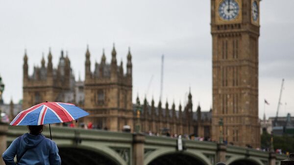 Pedestre com guarda-chuva representando a bandeira britânica em frente à torre Big Ben, no centro de Londres. Reino Unido, 31 de julho de 2023 - Sputnik Brasil