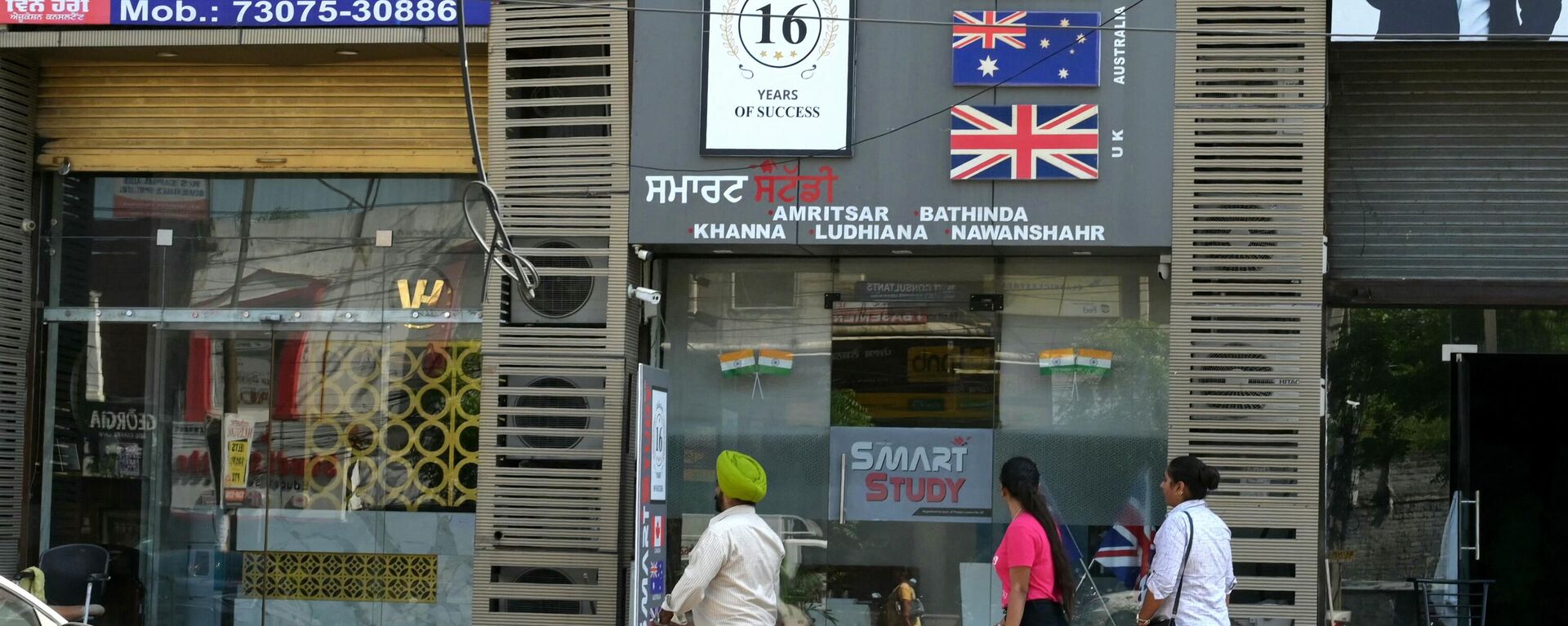 Pessoas passam por escritórios de consultoria de imigração em Jalandhar, Índia, 21 de setembro de 2023 - Sputnik Brasil, 1920, 22.09.2023