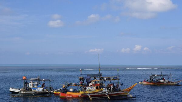 Barcos de pesca filipinos ancorados perto do Scarborough Shoal (fundo), controlado por Pequim, no disputado mar do Sul da China, 21 de setembro de 2023 - Sputnik Brasil