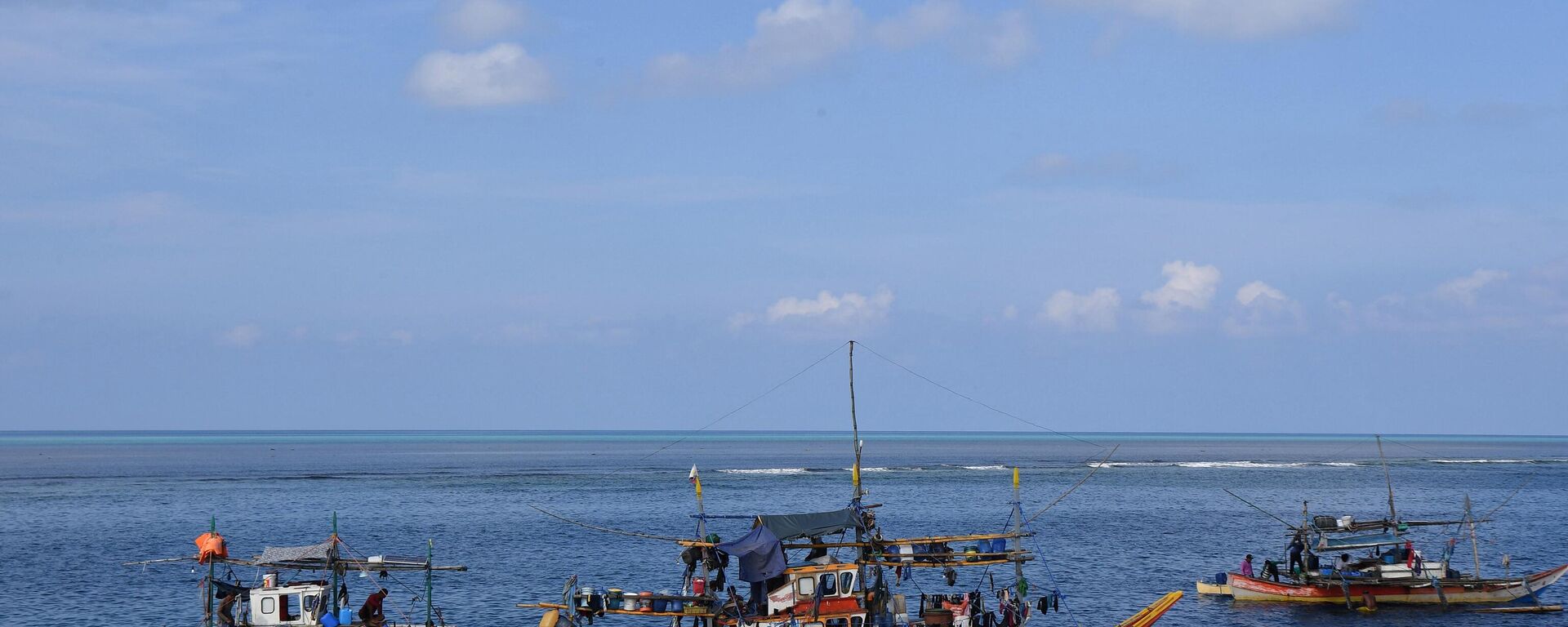 Barcos de pesca filipinos ancorados perto do Scarborough Shoal (fundo), controlado por Pequim, no disputado mar do Sul da China, 21 de setembro de 2023 - Sputnik Brasil, 1920, 24.09.2023