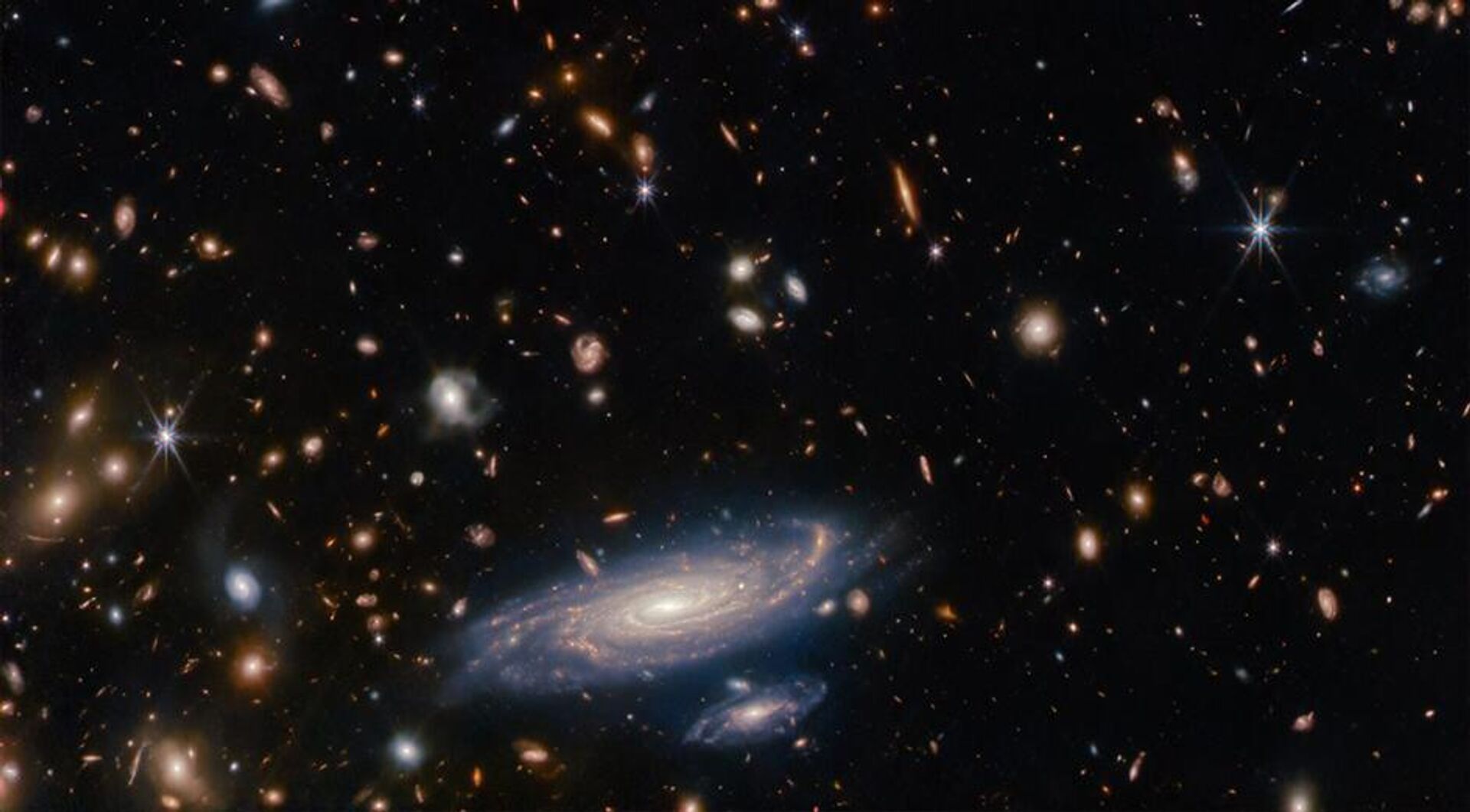 A galáxia em primeiro plano é LEDA 2046648, e é vista há pouco mais de 1 bilhão de anos, enquanto a maioria das outras ficam ainda mais distantes, vistas em um passado distante - Sputnik Brasil, 1920, 26.09.2023