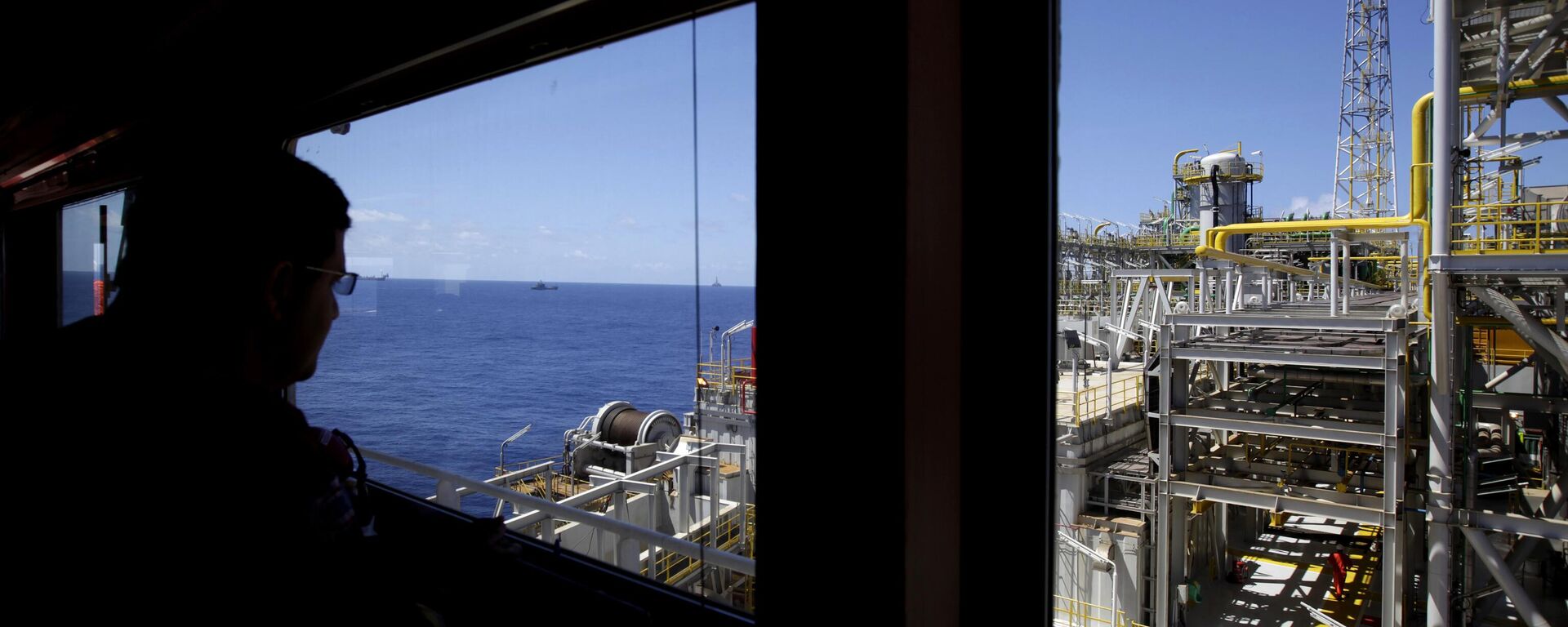 Um petroleiro olha para a plataforma offshore da Petrobras sobre o campo de Tupi, na baía de Santos, na costa do Rio de Janeiro, Brasil - Sputnik Brasil, 1920, 02.10.2023
