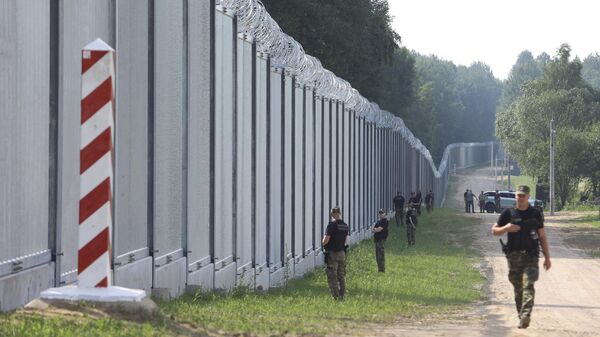 Guardas de fronteira poloneses patrulham a área de um muro de metal recém-construído na fronteira entre a Polônia e Belarus, perto de Kuznice, Polônia, em 30 de junho de 2022 - Sputnik Brasil