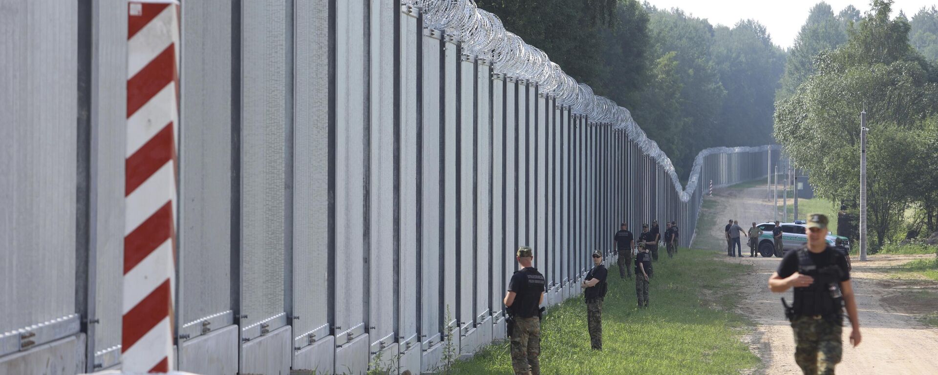 Guardas de fronteira poloneses patrulham a área de um muro de metal construído na fronteira entre a Polônia e Belarus, perto de Kuznice, em 30 de junho de 2022 - Sputnik Brasil, 1920, 16.10.2023
