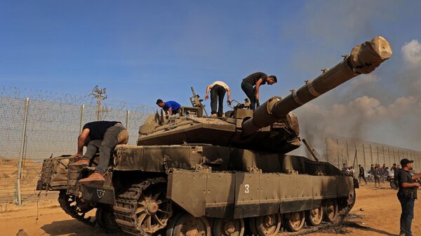 Palestinos assumem o controle de um tanque israelense depois de atravessar a cerca de fronteira com Israel de Khan Yunis no sul da Faixa de Gaza em 7 de outubro - Sputnik Brasil
