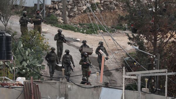 Soldados israelenses são fotografados na aldeia palestina de Kafr Dan, em Jenin, na Cisjordânia ocupada, em 2 de janeiro de 2023, durante uma operação para demolir as casas de dois palestinos acusados de matar um soldado israelense - Sputnik Brasil