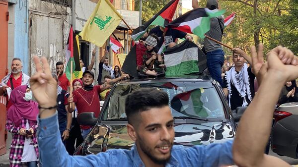 Manifestantes agitam bandeiras durante um comício contra a campanha militar israelense em Gaza. Beirute, Líbano, 14 de maio de 2021 - Sputnik Brasil