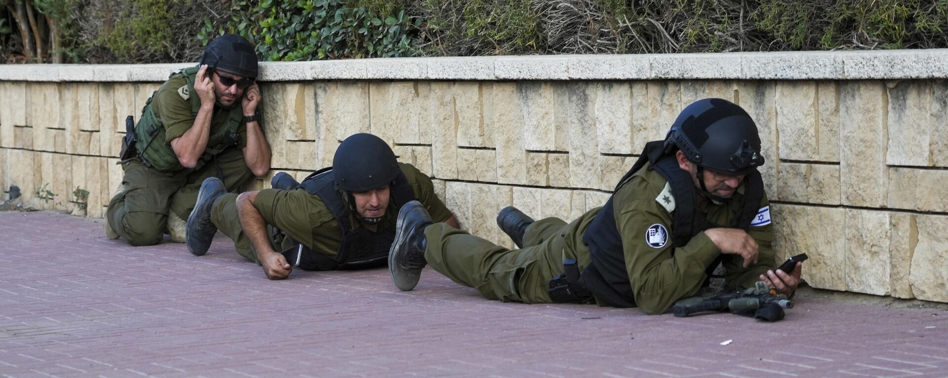 Soldados israelenses se protegem enquanto uma sirene soa um alerta sobre a chegada de foguetes disparados da Faixa de Gaza, em Ashkelon, Israel, 10 de outubro de 2023 - Sputnik Brasil, 1920, 10.10.2023