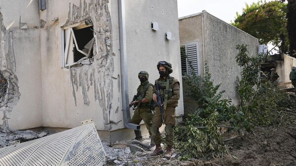 Soldados israelenses montam guarda no kibutz Kfar Azza, onde civis israelenses foram mortos pelo Hamas. Israel, 10 de outubro de 2023 - Sputnik Brasil