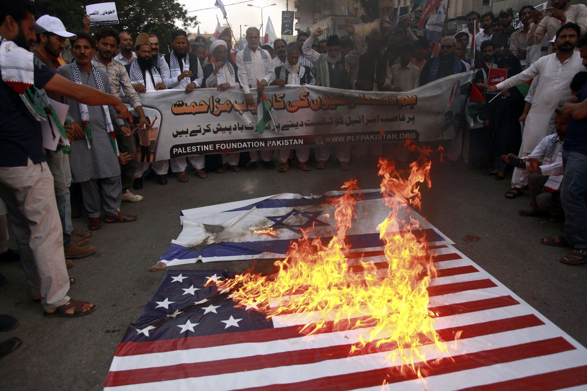 Apoiadores da Fundação Palestina Paquistão queimam representações das bandeiras israelense e americana enquanto entoam slogans contra os ataques aéreos israelenses em Gaza durante uma manifestação para mostrar solidariedade ao povo palestino, em Karachi, Paquistão, 8 de outubro de 2023 - Sputnik Brasil, 1920, 11.10.2023