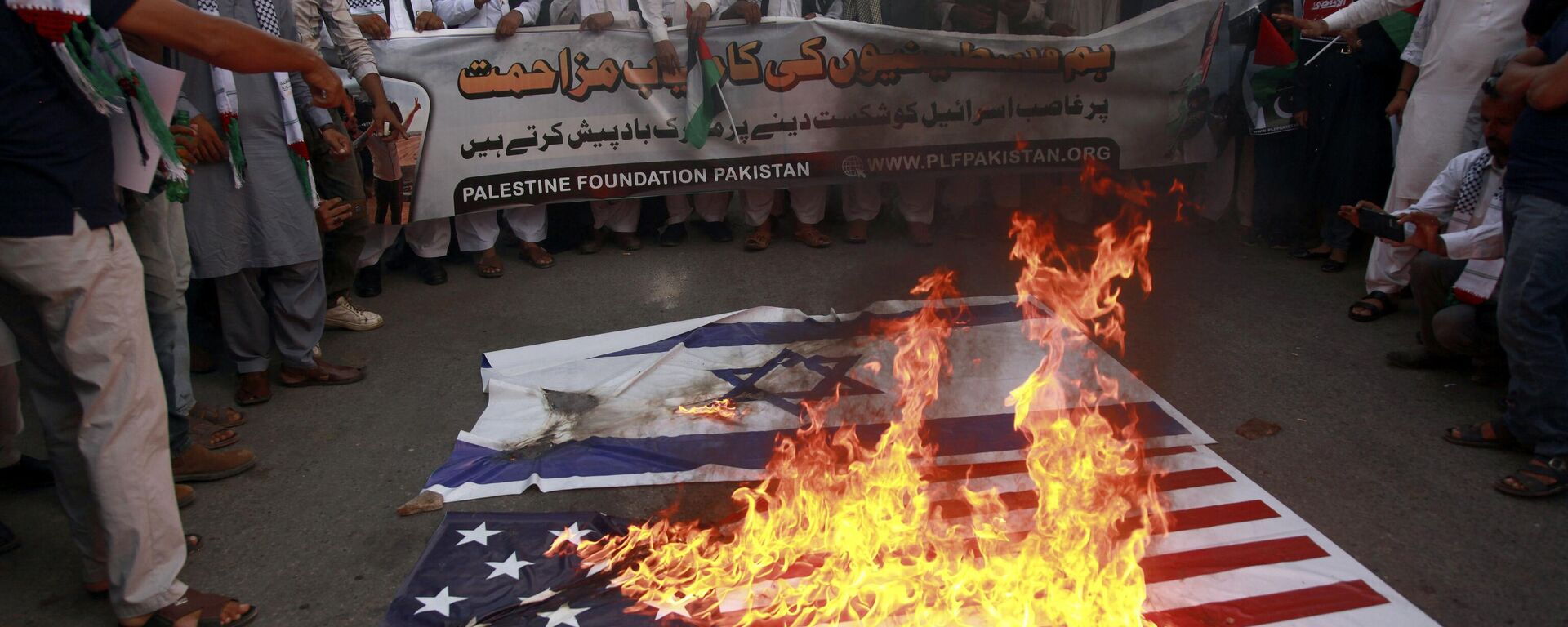 Apoiadores da Fundação Palestina Paquistão queimam representações das bandeiras israelense e americana enquanto entoam slogans contra os ataques aéreos israelenses em Gaza durante uma manifestação para mostrar solidariedade ao povo palestino, em Karachi, Paquistão, 8 de outubro de 2023 - Sputnik Brasil, 1920, 02.11.2023