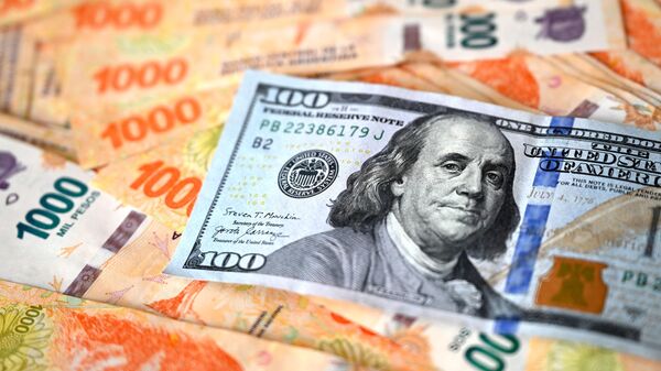 Esta imagem ilustrativa mostra uma nota de 100 dólares americanos em cima de pesos argentinos, em Buenos Aires, em 10 de outubro de 2023 - Sputnik Brasil