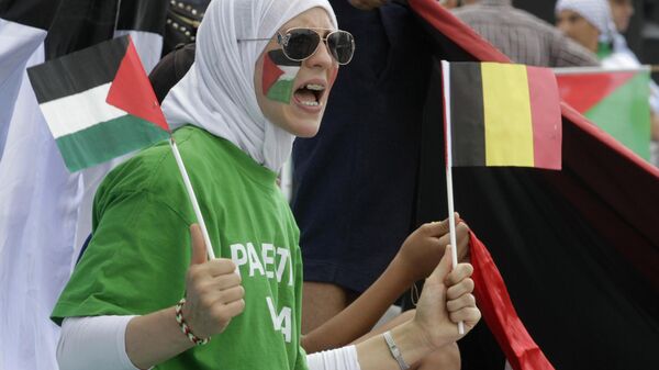 Mulher balança bandeiras da Palestina e da Bélgica durante manifestação pró-Palestina em Bruxelas (Bélgica), 25 de julho de 2014. - Sputnik Brasil