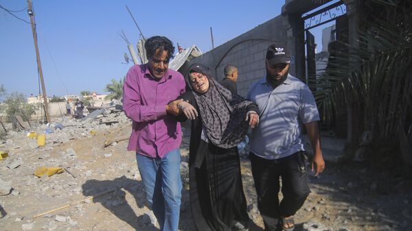 Palestinos evacuam uma mulher ferida após um ataque aéreo israelense em Rafah. Gaza, 13 de outubro de 2023 - Sputnik Brasil