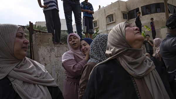 Palestinos lamentam parentes mortos em um ataque aéreo israelense na cidade de Gaza, em 9 de outubro de 2023 - Sputnik Brasil