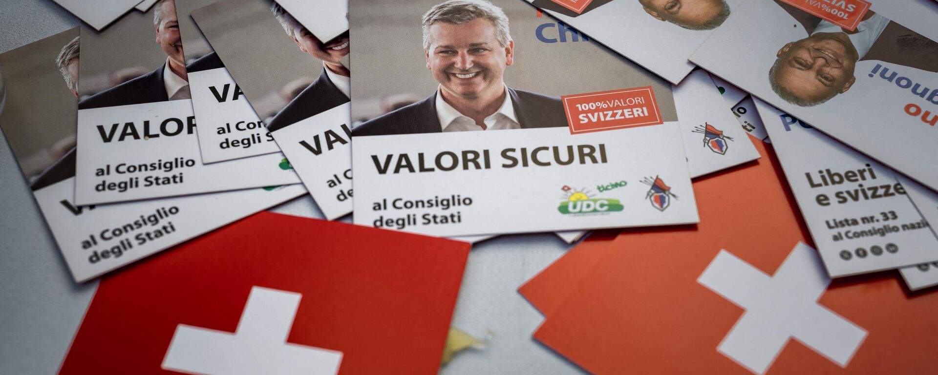 Folhetos eleitorais com o líder do Partido Popular Suíço (SVP UDC), Marco Chiesa (C), são vistos em um estande do partido do populismo de direita em 7 de outubro de 2023 em Lugano, sul da Suíça - Sputnik Brasil, 1920, 14.10.2023
