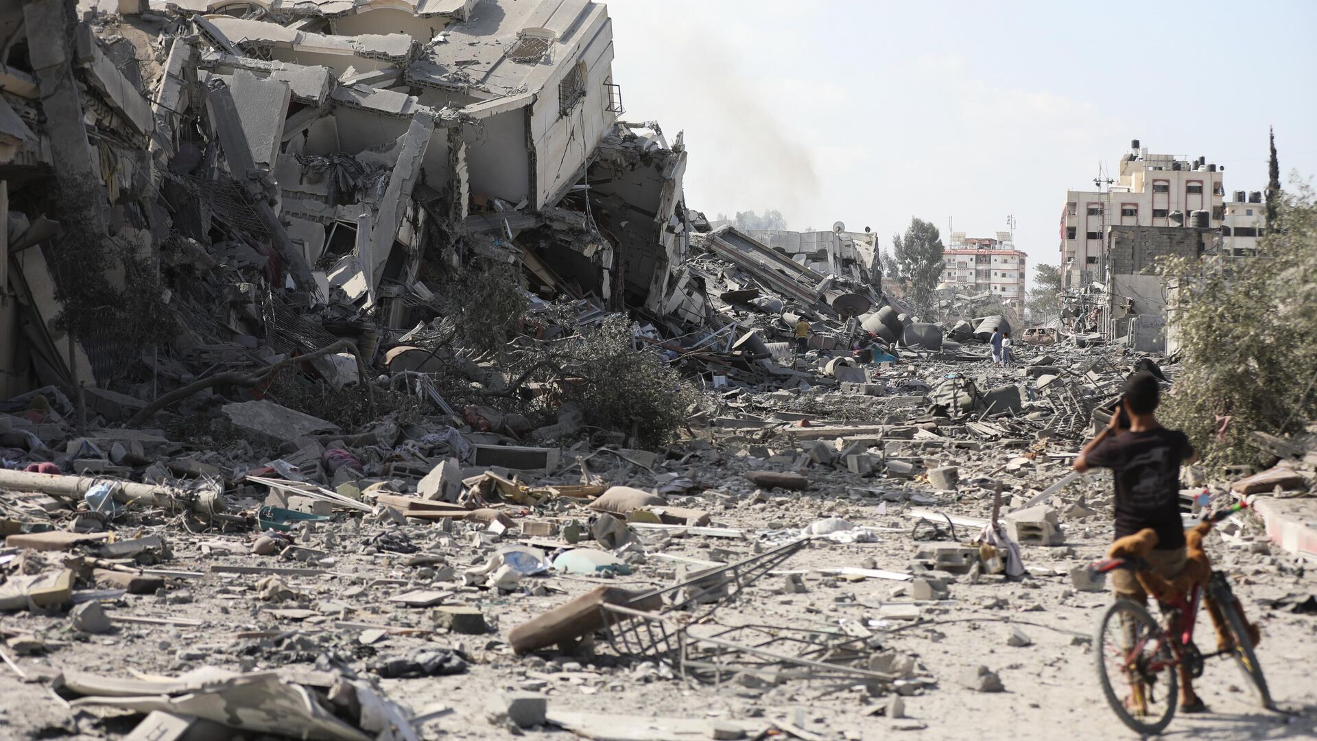 Menino palestino diante de edifícios destruídos por bombardeio israelense em Al-Zahra, nos arredores da cidade de Gaza, em 20 de outubro de 2023 - Sputnik Brasil, 1920, 31.10.2023