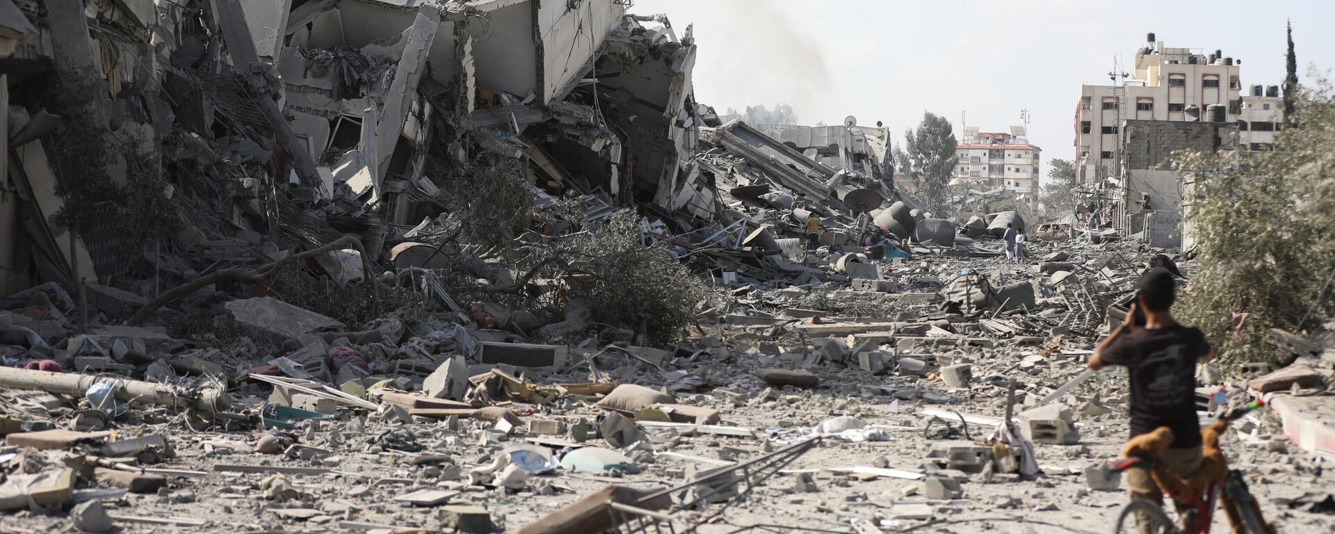 Menino palestino diante de edifícios destruídos por bombardeio israelense em Al-Zahra, nos arredores da cidade de Gaza, em 20 de outubro de 2023 - Sputnik Brasil, 1920, 30.10.2023