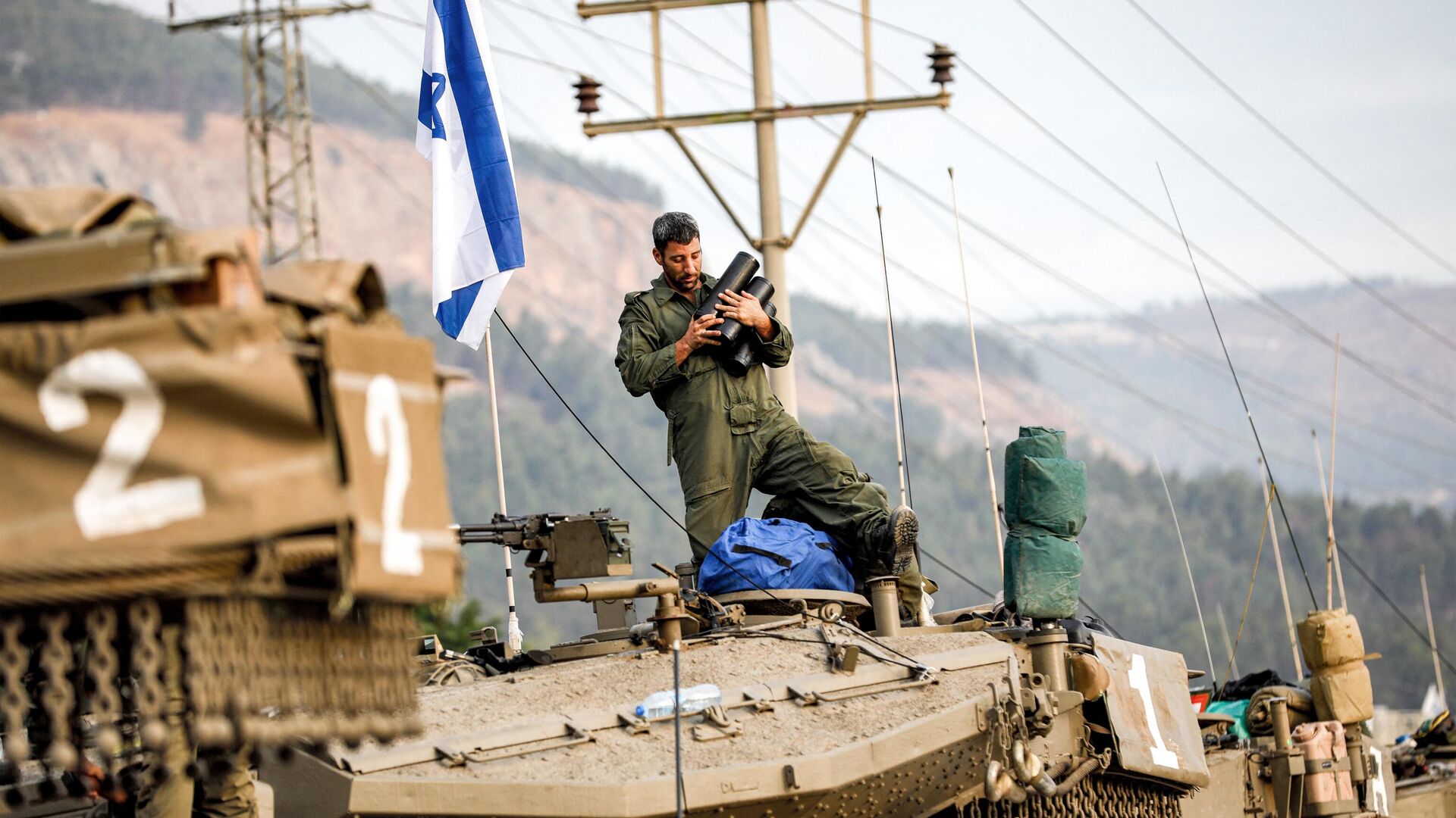 Soldado do Exército israelense segura projéteis no alto de um tanque Merkava, em meio a concentração de tanques na alta Galileia, no norte de Israel, perto da fronteira com o Líbano, em 11 de outubro de 2023 - Sputnik Brasil, 1920, 30.10.2023