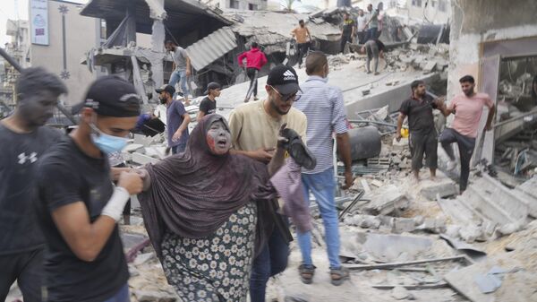 Palestinos evacuam sobreviventes após bombardeio israelense em Deir al-Balah. Faixa de Gaza, 22 de outubro de 2023 - Sputnik Brasil