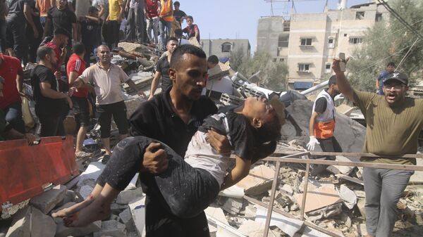 Palestinos tentam salvar pessoas que ficaram feridas após bombardeio israelense em área residencial na Faixa de Gaza. Rafah, 23 de outubro de 2023 - Sputnik Brasil