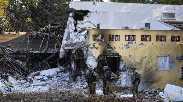 Soldados israelenses passam por casas destruídas por militantes do Hamas no kibutz Beeri, Israel, 14 de outubro de 2023 - Sputnik Brasil