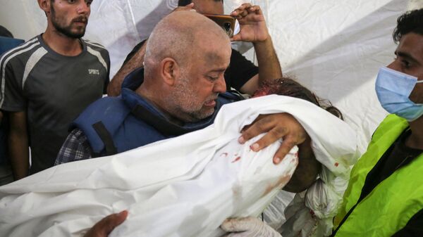 O correspondente da Al-Jazeera Wael Al-Dahdouh lamenta o corpo de um de seus três filhos que foram mortos junto com sua esposa em um ataque israelense no campo de Nuseirat em 25 de outubro de 2023 - Sputnik Brasil
