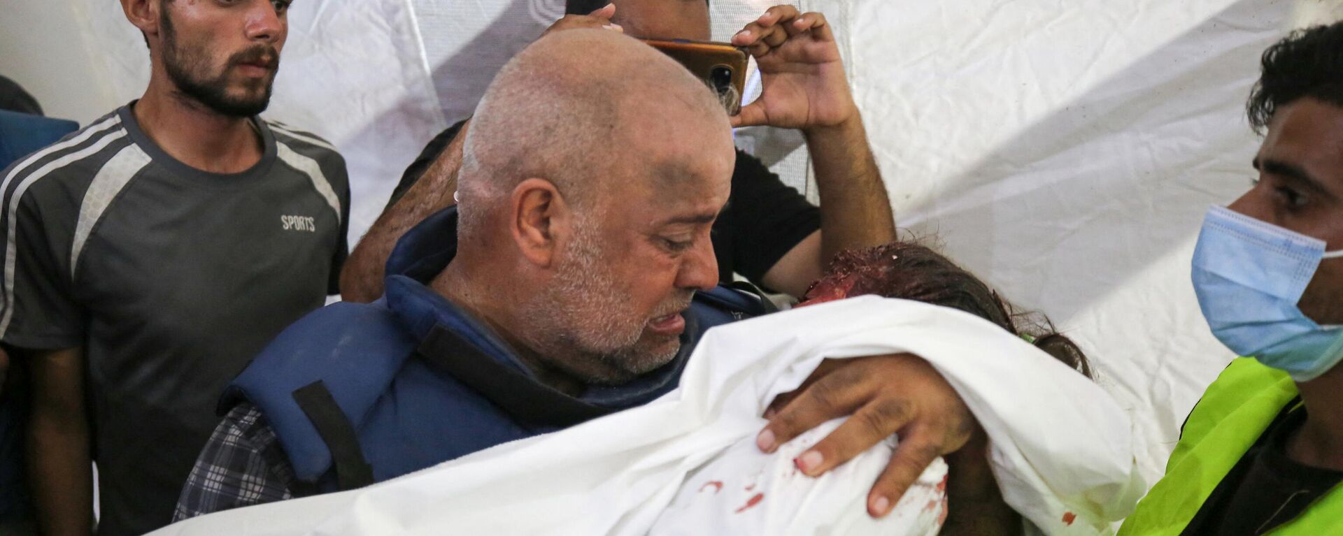 O correspondente da Al-Jazeera Wael Al-Dahdouh lamenta o corpo de um de seus três filhos que foram mortos junto com sua esposa em um ataque israelense no campo de Nuseirat em 25 de outubro de 2023 - Sputnik Brasil, 1920, 25.10.2023