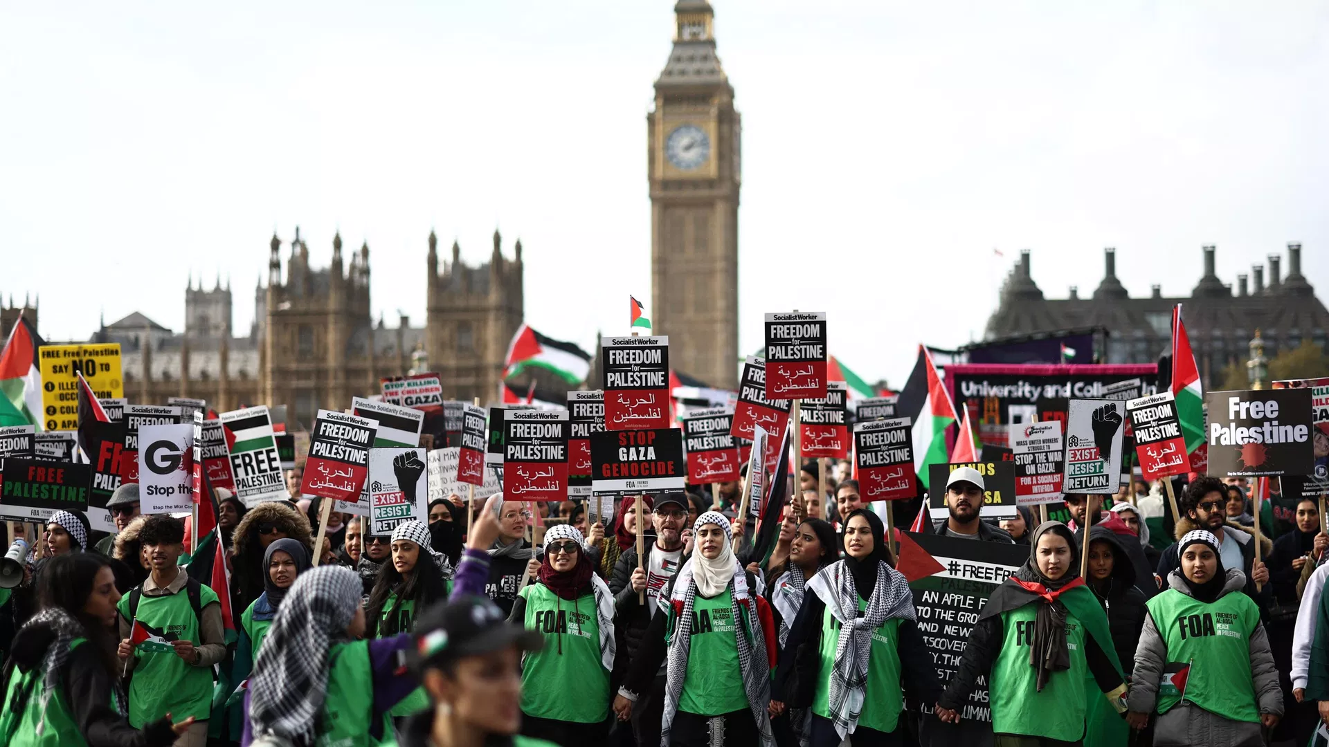 Manifestantes seguram cartazes enquanto caminham pela Ponte de Westminster com o Palácio de Westminster, sede das Casas do Parlamento, durante uma 'Marcha pela Palestina' em Londres, em 28 de outubro de 2023 - Sputnik Brasil, 1920, 28.10.2023