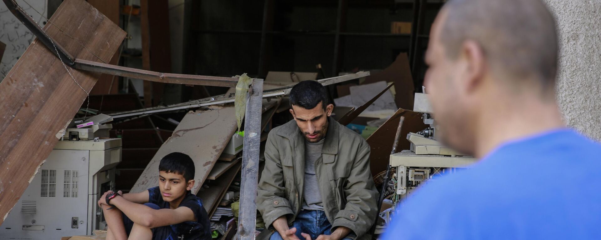 Palestinos sentam-se nas ruínas de uma casa após um recente bombardeio nas ruas da Cidade de Gaza, na Palestina. - Sputnik Brasil, 1920, 31.10.2023