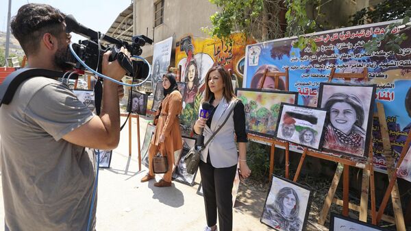Repórter da Al Jazeera cobre exposição de arte em homenagem à sua falecida colega, a jornalista palestina Shireen Abu Akleh, no local onde a veterana jornalista de TV foi morta em 11 de maio de 2022, enquanto cobria um ataque do Exército israelense em Jenin - Sputnik Brasil