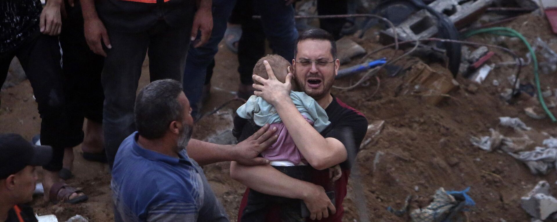 Um homem palestino chora enquanto segura uma criança morta que foi encontrada sob os escombros de um prédio destruído após ataques aéreos israelenses no campo de refugiados de Nusseirat, centro da Faixa de Gaza, 31 de outubro de 2023 - Sputnik Brasil, 1920, 02.11.2023