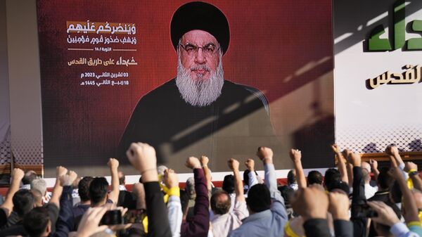 Apoiadores do grupo militante Hezbollah erguem os punhos e aplaudem o pronunciamento do líder do Hezbollah, Hassan Nasrallah, 3 de novembro de 2023 - Sputnik Brasil