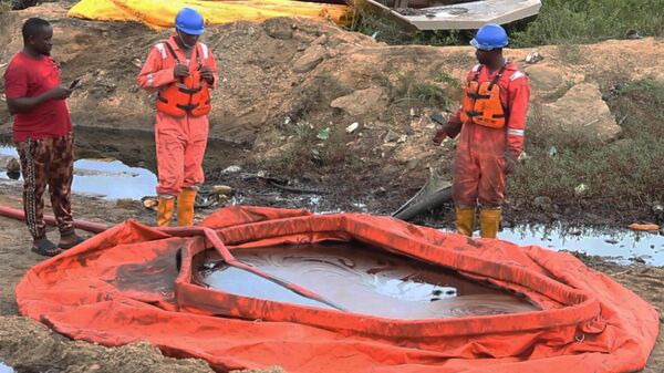 Trabalhadores ao lado de contêiner para coleta de resíduos de derramamento de óleo, em Ogoniland. Nigéria, 16 de junho de 2023 - Sputnik Brasil