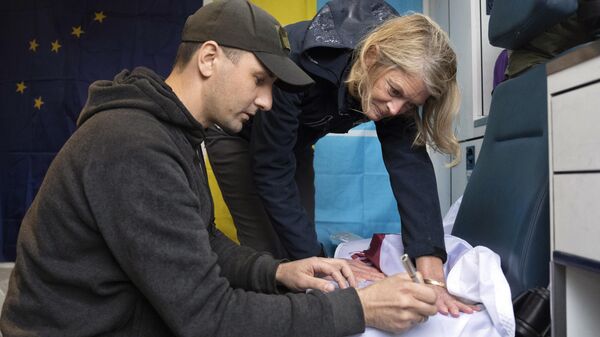 Soldado ucraniano escreve seus desejos em bandeira do país para a senadora americana Lisa Murkowski, em Kiev. Ucrânia, 12 de abril de 2023 - Sputnik Brasil