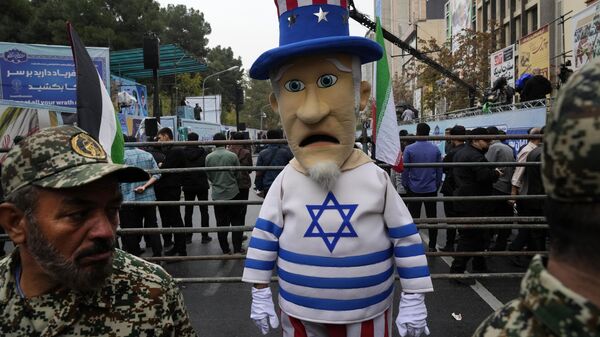 Homem iraniano usa fantasia do Tio Sam com a bandeira de Israel durante manifestação em frente à antiga Embaixada dos EUA, marcando o 44º aniversário da tomada da embaixada por estudantes iranianos militantes, em Teerã, Irã, 4 de novembro de 2023 - Sputnik Brasil