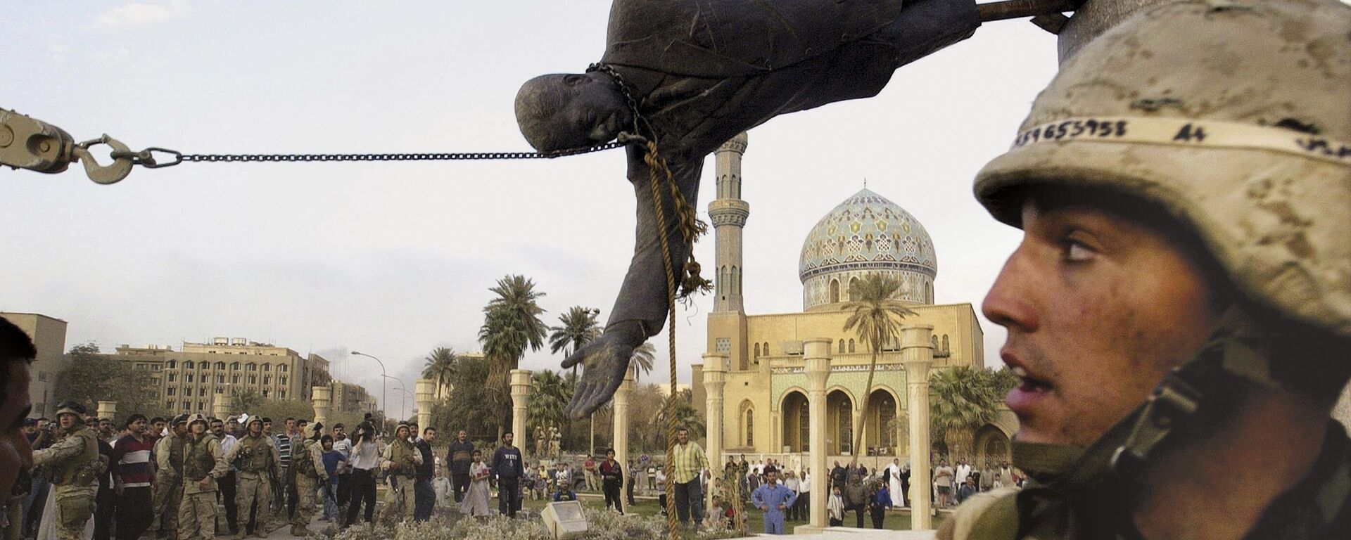 Civis iraquianos e soldados norte-americanos derrubam uma estátua de Saddam Hussein no centro de Bagdá, em 9 de abril de 2003 - Sputnik Brasil, 1920, 10.11.2023