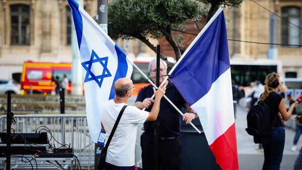 Manifestantes arrumam uma bandeira nacional israelense e uma bandeira nacional francesa durante manifestação em apoio ao povo de Israel em Marselha, sul da França, em 9 de outubro de 2023 - Sputnik Brasil