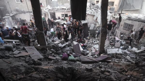 Palestinos em meio à destruição provocada por ataque aéreo israelense em campo de refugiados na Faixa de Gaza. Khan Younis, 13 de novembro de 2023 - Sputnik Brasil