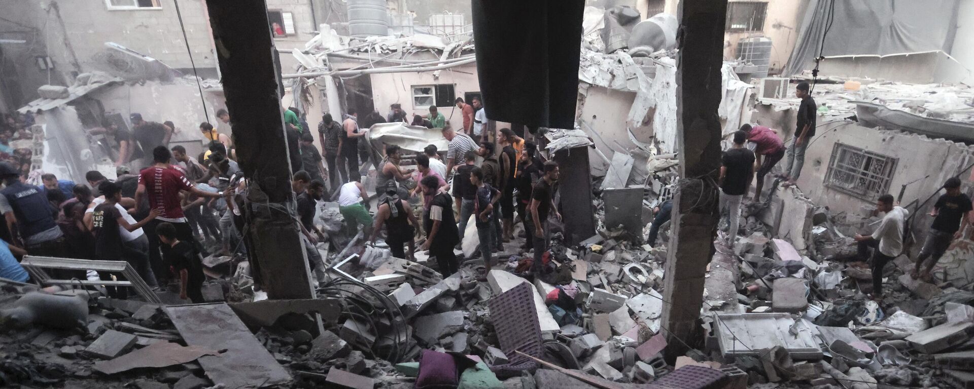 Palestinos em meio à destruição provocada por ataque aéreo israelense em campo de refugiados na Faixa de Gaza. Khan Yunis, 13 de novembro de 2023 - Sputnik Brasil, 1920, 12.03.2024