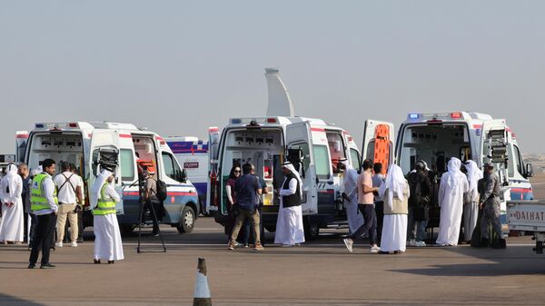 Voluntários e ambulâncias aguardam chegada do avião que transporta palestinos evacuados da Faixa de Gaza como parte de uma missão humanitária organizada pelos Emirados Árabes Unidos, na pista de Abu Dhabi, Emirados Árabes Unidos, 18 de novembro de 2023 - Sputnik Brasil