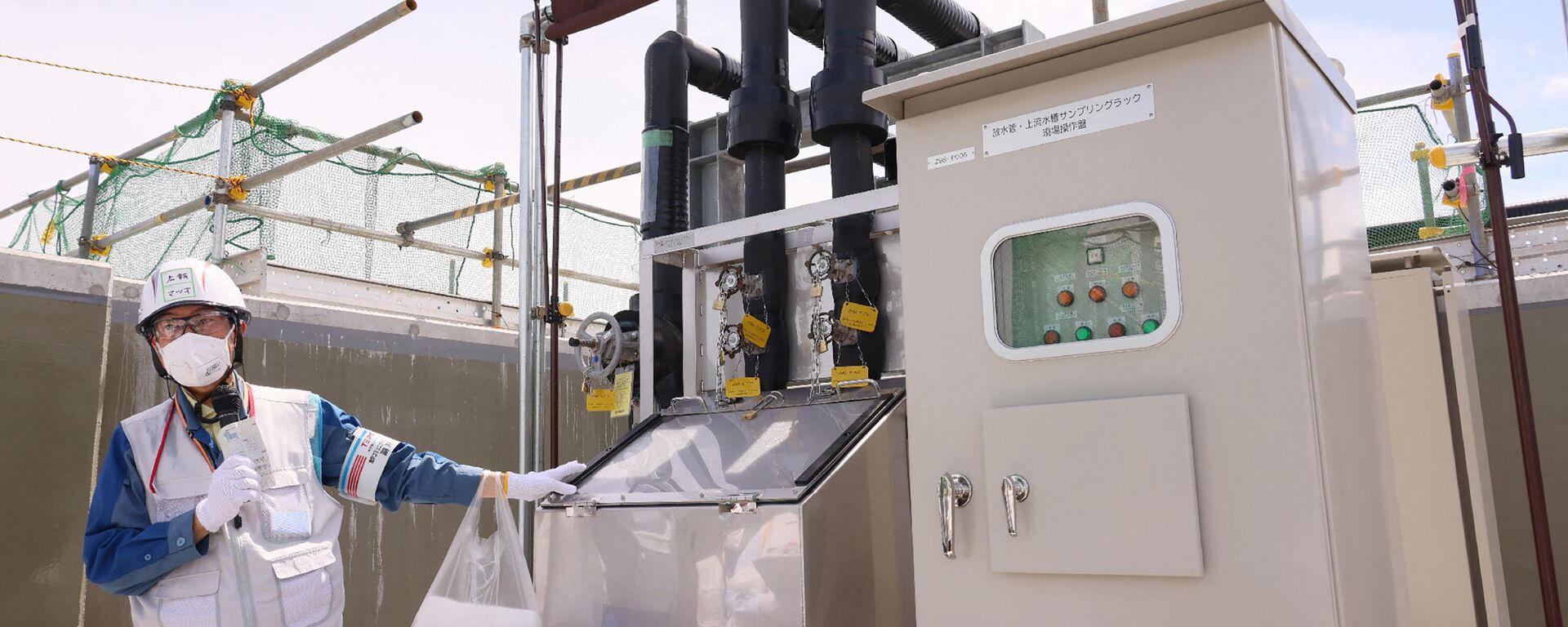 Um funcionário apresenta um equipamento para amostragem de água, a fim de analisar a concentração de trítio radioativo antes de descarregar a água tratada diluída como parte da instalação para a liberação de água tratada da usina nuclear de Fukushima. Okuma, 27 de agosto de 2023 - Sputnik Brasil, 1920, 22.11.2023