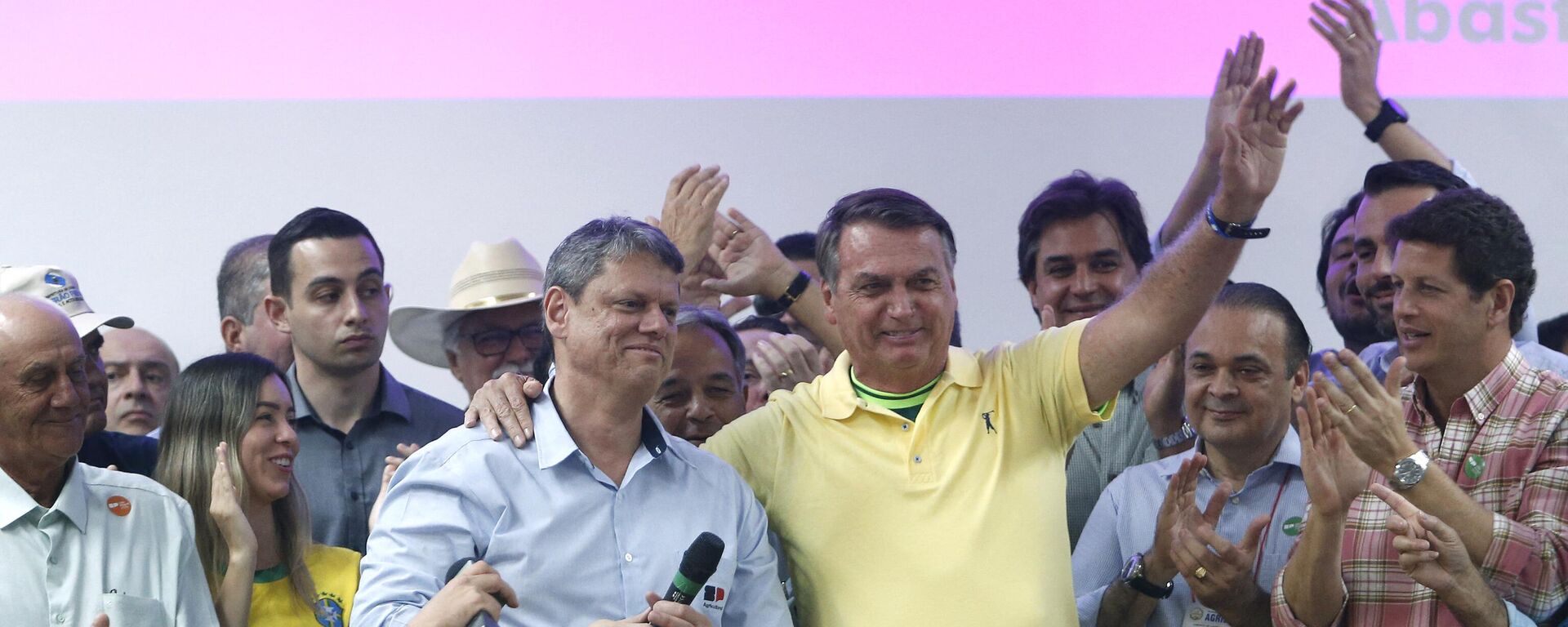 O ex-presidente brasileiro Jair Bolsonaro (D) e o governador do estado de São Paulo Tarcisio de Freitas (E) acenam durante a cerimônia de abertura da feira Agrishow em Ribeirão Preto. São Paulo, 1º de maio de 2023 - Sputnik Brasil, 1920, 22.11.2023