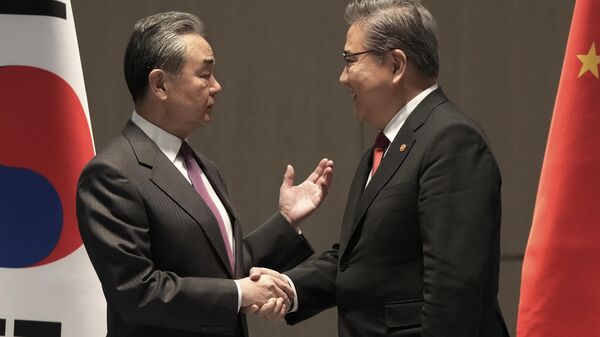 Wang Yi (à esquerda) e Park Jin (à direita), ministros das Relações Exteriores da China e da Coreia do Sul, respectivamente, conversam antes de reunião em Busan, Coreia do Sul, 26 de novembro de 2023 - Sputnik Brasil