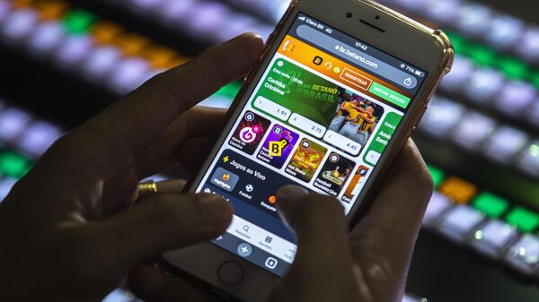 Uma pessoa manipula um celular em um site de apostas esportivas. Brasília, 14 de março de 2023 - Sputnik Brasil