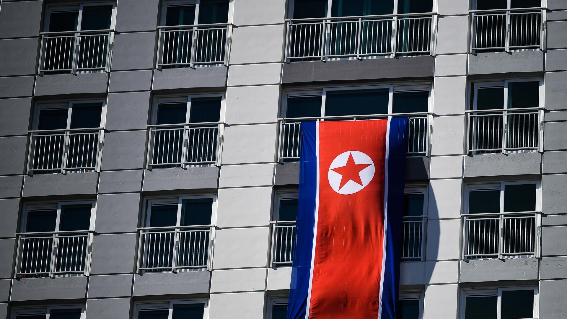 A bandeira da República Popular Democrática da Coreia na varanda de um hotel na Vila Olímpica de Gangneung em 6 de fevereiro de 2018 - Sputnik Brasil, 1920, 28.01.2024