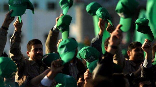 Os apoiadores palestinos do Hamas erguem seus chapéus verdes durante uma manifestação celebrando a vitória do grupo nas eleições parlamentares, no Campo de Refugiados Khan Younis, no sul da Faixa de Gaza, em 27 de janeiro de 2006 - Sputnik Brasil